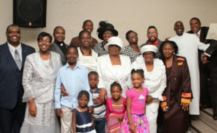 Pastor and members standing by the pulpit in the 10th street building in 2016